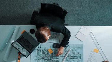 İş kadınının proje planı, ekipman ve güvenlik kaskıyla toplantı masasında oturan mühendis el planının en üst görüntüsü. Yöneticinin hava görüntüsü bina inşaatını açıklıyor. Hizalama.