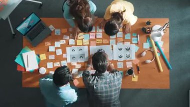 İş dünyasının zaman atlaması renkli notlarla toplantı masasına grafik logosu koydu ve fikri açıklarken tasarım yapmaya başladı. Proje yöneticisi grup halinde yürürken konsept sanatı anlatıyor. Sempozyum.