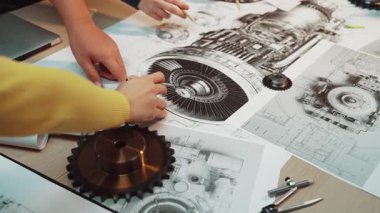 Mühendisler, yenilikçi projelerin tasarım ve geliştirme sürecini geliştirmek için teknik çizimler ve mekanik bileşenleri inceleyerek atölye ortamında işbirliği yaparlar. SACTR