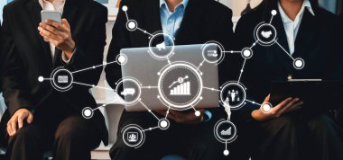 Dizüstü bilgisayarlar ve akıllı telefonlar kullanarak veri analizi yapan bir iş ekibi, büyüme ve yeniliğe odaklanmış profesyonel bir ortamda dijital bağlantıların önemini gözler önüne seriyor. Dostluk