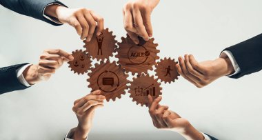 Bu resim, iş ortamında çevik metodolojiyi ve etkili takım çalışmasını sembolize eden, dişlilerle işbirliği yapan çeşitli profesyonellerden oluşan bir ekibi tasvir ediyor. Dostluk