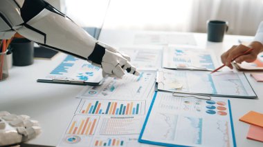 Modern bir ofiste iş analitik belgelerinde işbirliği yapan bir robot kol, teknoloji ve veri analizinin profesyonel ortamlarda entegrasyonunu gösteriyor. Noogenesis