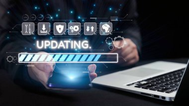 Teknolojiyi güncelleme sürecini gösteren canlı bir sahne, her ikisi de modern bir dijital arayüzü gösteren akıllı telefon ve dizüstü bilgisayarı tutan bir el. Dörtgen