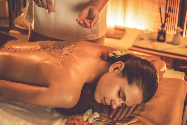 Женщина-клиент, проводящая пилинг в роскошном спа-салоне с теплым свечой окружающей среды. Косметическое лечение бальзамическим скрабом в Health spa scrub. Quiescent