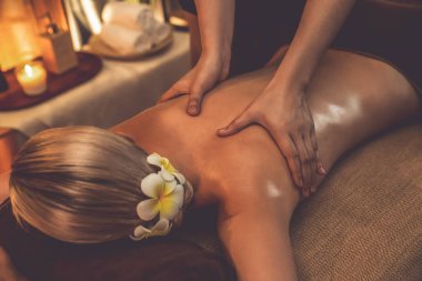 Yakından kadın müşteri strese karşı spa masajını rahatlatıyor ve lüks otel ya da otelde sıcak mum ışığında güzellik teniyle eğleniyor. Sessiz.