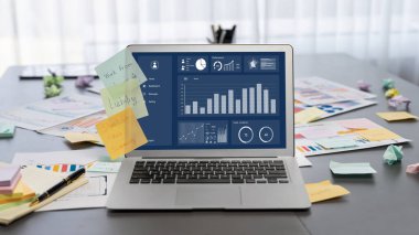 İş fikri için yaratıcı ve analitik beyin fırtınası için yapışkan bir not ve dizüstü bilgisayarında BI veri paneli var. Pazarlama stratejisi için finansal veri görselleştirme teknolojisini analiz et. Dahi.