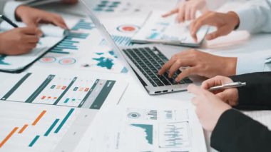 Modern ofis ortamında dizüstü bilgisayarlar, çizelgeler ve grafikler kullanılarak yapılan ve işbirliğini ve stratejik planlamayı teşvik eden dinamik bir iş toplantısı. SACTR