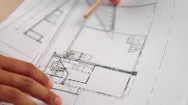 Ölçüm ve yazma aracını kullanarak mimari ofisindeki inşaat doğruluğu için ayrıntılı bir plan tasarlayan akıllı mimar ya da akıllı mühendisin videosu. Eline odaklan. - Yakın çekim. Tanımlama.