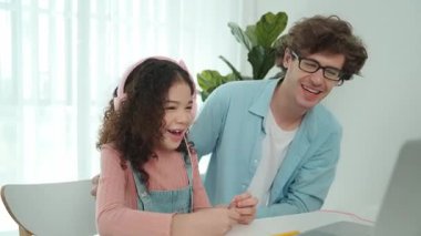 Amerikalı kız, kod yazmayı ve mühendislik yazmayı öğrenirken olumlu baba da birlikte çalışıyor ve programlama kodunu veya sistemini özenle göstermek için dizüstü bilgisayarına işaret ediyor. Pedagoji.