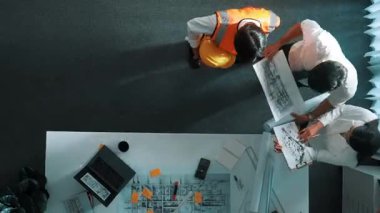 Akıllı mimar ve yetenekli inşaat mühendisi ekibinin, bina inşaatı için birlikte çalışırken proje, ekipman ve güvenlik kaskıyla toplantı masasında durmasının en iyi görüntüsü. Hizalama.