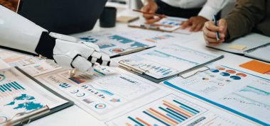 Profosyonel bir ekibe çizelgeleri, grafikleri ve raporları analiz etmede yardımcı olan modern bir iş sahnesi. Noogenesis