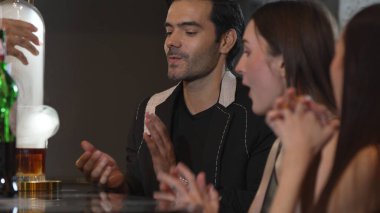 Duman çıkaran dumanlı bir barmen kokteyl sunumuyla viskiyi karıştırıyor. Grup misafirlerine içki tezgahında özel hoş geldin içkisi öneriyor. Vinosity.