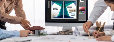 İç mimar tasarımcı grubu, daha kesin tasarım için planlar ve dizüstü bilgisayar ekran mimari yazılımı üzerinde birlikte tartışıyorlar. Modern ev tasarımı ve yenileme. İçgörü