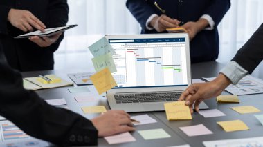 Analizci ekibi yaratıcı ve analitik beyin fırtınası fikri için bilgisayar ekranında BI veri paneli olan yapışkan bir not kullanıyor. Pazarlama stratejisi için finansal veri görselleştirme teknolojisini analiz et. Dahi.