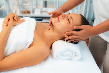 Kafkasyalı kadın stres önleyici kafa masajından ve lüks tatil beldesi ya da otel spa salonundaki modern ışık ortamında yüz güzelliği eğlencelerini şımartmaktan hoşlanıyor. Sessiz.