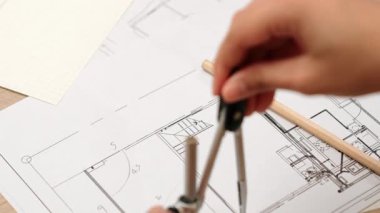 Bölücü araç ve el yazısı kullanan akıllı mimar ya da güvenlik mühendisinin videosu mimari ofisteki inşaat doğruluğu planının ayrıntılarını içeriyor. Eline odaklan. - Yakın çekim. Tanımlama.