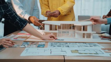 Mimarlardan oluşan dinamik bir ekip, yeni projeler için yenilikçi bina tasarımları ve çözümler planlarken, fikirlerini ve çizimlerini paylaştığı çağdaş bir ofiste işbirliği yapıyor. SACTR