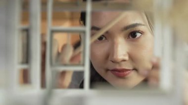 İnşaatı incelerken, profesyonel mimar mühendisinin yüzü ev modelini inceliyor. Proje yöneticisi ev modelini kontrol ediyor. İş tasarımı konsepti. Yüzüne odaklan. Yönlendirici.