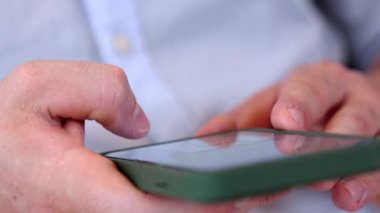 Orta yaşlı bir adam oturma odasındaki koltukta oturur telefon arama verilerini kullanır çocukları iyi bir yetişkin baba ya da eğlence olarak yetiştirir. İşadamı teknolojiyi kolaylık için kullanır. Uyumsuzluk.