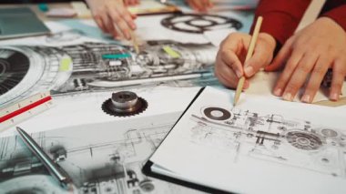 Bir uçak motorunun detaylı teknik çizimlerini gösteren canlı bir çalışma alanı. Elleri, mühendislik araçlarıyla çevrili, çizim ve ölçüm bileşenleriyle meşgul. SACTR