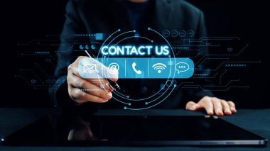 Bir iş adamı, e-posta ve telefon gibi iletişim seçeneklerini gösteren dijital bir arayüzle etkileşime girer. Görüntü, teknoloji meraklısı bir dünyada modern iletişimi gösteriyor. Dörtgen