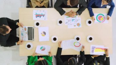 İş adamları grup toplantısı ofiste yukarıdan çekildi. İş kadınları, iş adamları ve ofis çalışanları, proje planlama belgeleriyle takım konferansında toplantı masasında çalışıyorlar. .