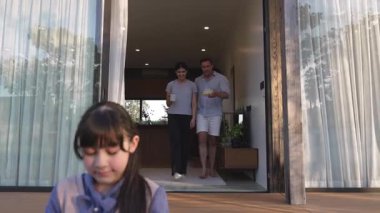 Şirin baba, anne ve kızı birlikte evin bahçesinde oturuyorlar. Ebeveynler, çevre farkındalığıyla ilgili genç nesli iletişim kurmak için açık hava aktivitelerini kullanırlar. Uyumsuzluk.