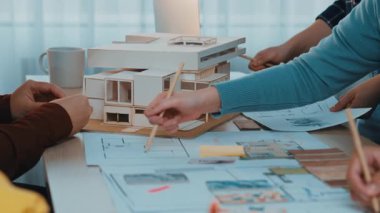 İşbirlikçi bir ekip modern bir ofiste mimari bir model ve planlar hakkında anlamlı bir tartışmaya girişiyor, tasarımda yaratıcılık ve takım çalışması sergiliyor. SACTR