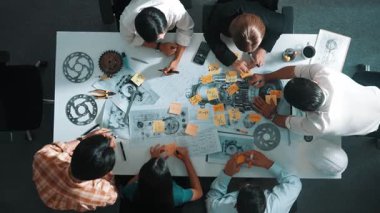 Üstten görünüşlü akıllı mühendis ekibi metal teçhizatlı, hesap makineli, yapışkan notlu türbin motor yapısı hakkında konuşuyor. Bir grup teknisyen toplantıda not alıyor. Hizalama.