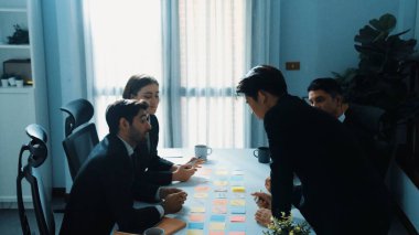 Üst düzey iş adamları pazarlama stratejisini tartışırken akıllı yöneticiler toplantıya girip plan hakkında konuşuyorlar. Çeşitli insanlar toplantı odasında yapışkan notlar kullanarak beyin fırtınası yapıyorlar. Müdürlük.