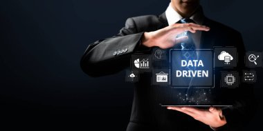 Takım elbiseli bir profesyonel, iş görüşleri, gelişmiş analitik ve görselleştirme teknikleri için bulut teknolojisi kullanan veri odaklı bir strateji sunar. XDMCP