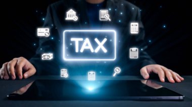 Bir işadamı, parlayan finansal simgelerle çevrili, vergi idaresi için dijital tablet kullanır. Bu görüntü, teknolojinin modern finansal süreçlere entegrasyonunu temsil ediyor. Dörtgen