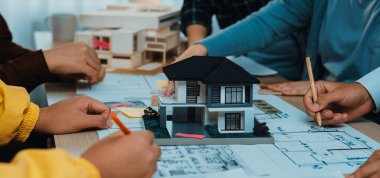 Mimari planlamayla ilgilenen dinamik bir grup, merkezinde bir model ev bulunan planlar üzerinde çalışan, tasarımda takım çalışması ve yaratıcılığı sergileyen. SACTR