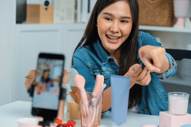 Genç, güzel Asyalı kozmetik makyaj ruju matte pastel rengini modern odadaki sosyal medyada kol testi tanıtımında en çok satanlar listesinde gösteriyor. Taktik.