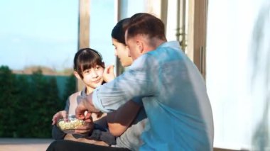 Güzel bir evlilik çifti ve kızı açık terasta piknik yapıyor. Açık hava aktivitelerini kullanan aile, çocuk için iyi bir büyüme, güçlü bir aile bağı ya da ilişkiyi güçlendirmek için sevgi ve özen göstermektedir. Uyumsuzluk.