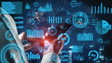 Bir işadamı, gelecekteki bir ortamda finansal veri ve analizi temsil eden dijital grafik ve grafiklerle çevrili, çağdaş bir ofiste akıllı bir telefonla meşgul oluyor. Xenic