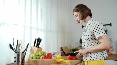 Çekici beyaz anne salata yapmak için taze sebze doğruyor. Mutlu enerjik akıllı anne kahvaltıda sağlıklı yemek pişirirken modern mutfakta çalışıyor. Yemek hazırlama konsepti. Pedagoji.