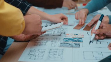 Bir grup profesyonel, bir çalışma masasında notlar, çizimler ve görsel yardımlarla beyin fırtınası ve planlama üzerine yoğunlaşarak birlikte yaratıcı bir sürece giriştiler. SACTR