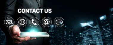 Modern bir şehirde, e-posta, telefon ve sohbet gibi iletişim ikonlarının yer aldığı, bağlantıyı sembolize eden müşteri hizmetleri desteği arayan bir işadamı. XDMCP