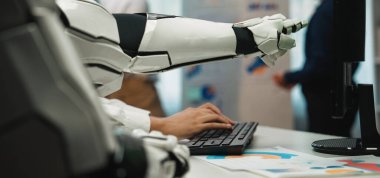 Bir robotik kol modern bir ofiste klavyeyle etkileşime girerek ileri teknoloji ve insan çalışmaları arasındaki sinerjiyi vurguluyor. Noogenesis