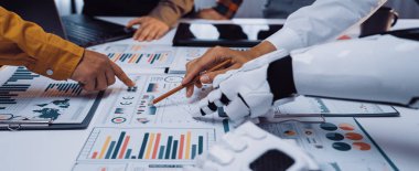 İş yerindeki insan ve robot işbirliğinin dinamik bir sahnesi, grafik ve çizelgeler yoluyla veri analizini göstermek, yenilik ve takım çalışmasını vurgulamak. Noogenesis