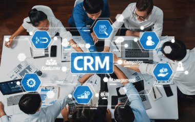 Çeşitli bir ekip modern bir ofis ortamında, müşteri ilişkileri yönetim stratejilerini tartışırken etkili veri analizi için çeşitli teknolojik araçlar kullanır. Dostluk