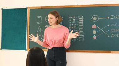 Zeki öğretmen sınıfta fikri açıklarken sevimli öğrenci ödevlerini kontrol ediyor. Not defterine bakıp matematik teorisinden çocuğa bahsederken sınıfta dolaşan çekici bir eğitmen. Pedagoji.