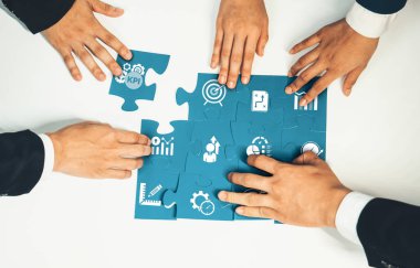 Üst düzey panorama panorama iş adamlarının masa üzerinde yapboz yapbozu yapmaları, iş ortaklığını ve insan kaynakları için kolektif takım çalışmasını ve iş arayan geçmişini sembolize ediyor. Kurnaz Dostluk