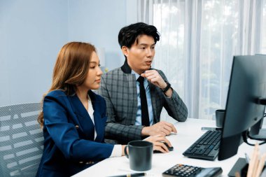 İki ekranda pazarlama raporunu analiz eden Asyalı iş arkadaşları değer borsası veritabanını modern ofisteki online raporla karşılaştırıyorlar. Değer yatırım şirketinin analizi. İnfobahn.