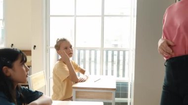 Akıllı beyaz çocuk elini kaldırıp tahtaya cevap yazmak için gönüllü oldu. Öğretmen, mutlu öğrenci tebeşir alırken ve sınıfın önünde yürürken soruyu cevaplamak için gönüllü olmayı talep ediyor. Pedagoji.