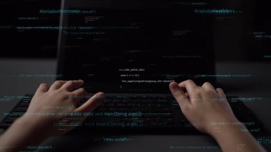 Modern yazılım geliştirme ve yaratıcılığın özünü özetleyen kod ve programlama dilleri satırlarıyla çevrili bir klavyede el yazısının yakın plan görüntüsü. Xenic