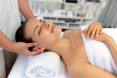 Kafkasyalı kadın stres önleyici kafa masajından ve lüks tatil beldesi ya da otel spa salonundaki modern ışık ortamında yüz güzelliği eğlencelerini şımartmaktan hoşlanıyor. Sessiz.