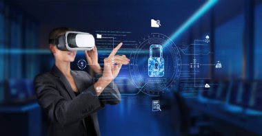 Profesyonel bir kadın sanal gerçeklik kulaklığı takıyor, fütüristik bir iş alanında siber güvenlik kavramlarını keşfediyor, veri koruması ve gizlilik uygulamalarını vurguluyor. XDMCP