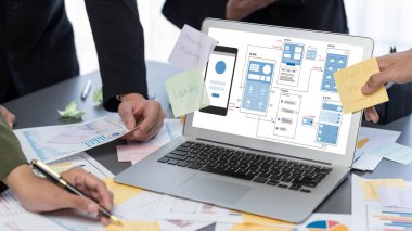 Analizci ekibi yaratıcı ve analitik beyin fırtınası fikri için bilgisayar ekranında BI veri paneli olan yapışkan bir not kullanıyor. Pazarlama stratejisi için finansal veri görselleştirme teknolojisini analiz et. Dahi.